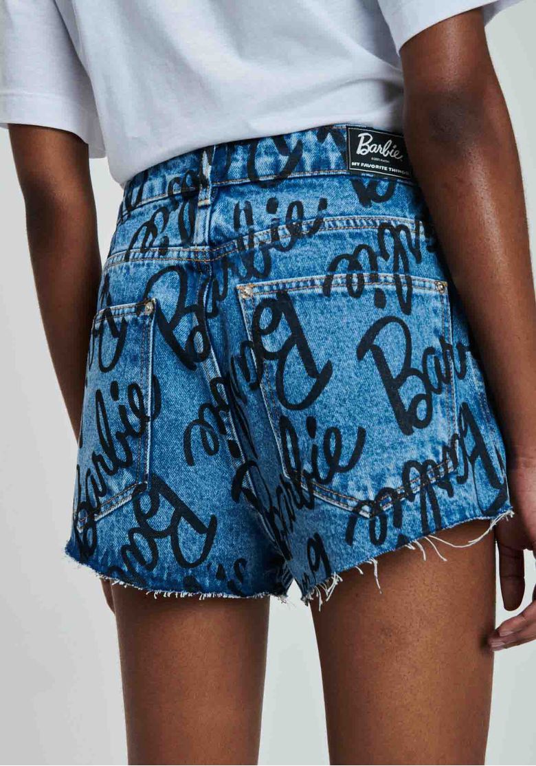 Vista-traseira-do-short-jeans-azul-Barbie-com-estampa-lettering-bolsos-traseiros-e-barra-desfiada