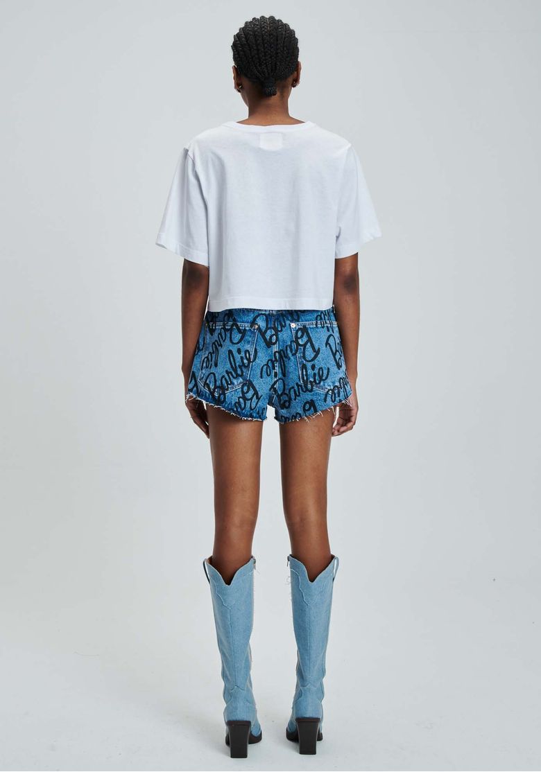 Vista-costas-do-look-com-short-jeans-azul-Barbie-estampado-camiseta-branca-e-bota-azul-de-cano-alto