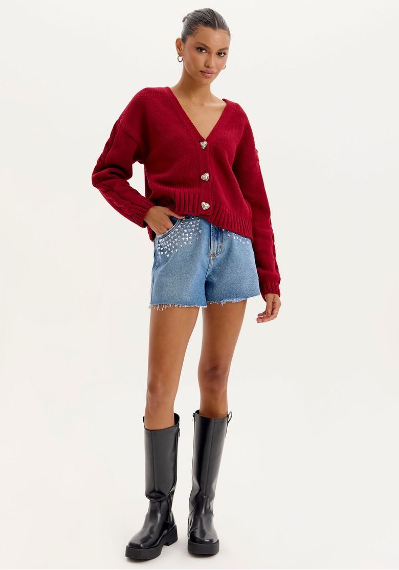 Modelo vestindo short jeans grandfather com blusa vermelha e botas pretas.