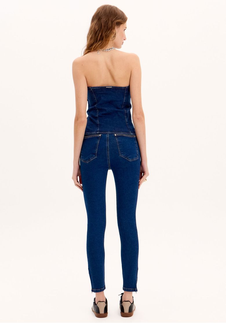 Vista traseira da calça jeans skinny ankle azul com bolsos embutidos.
