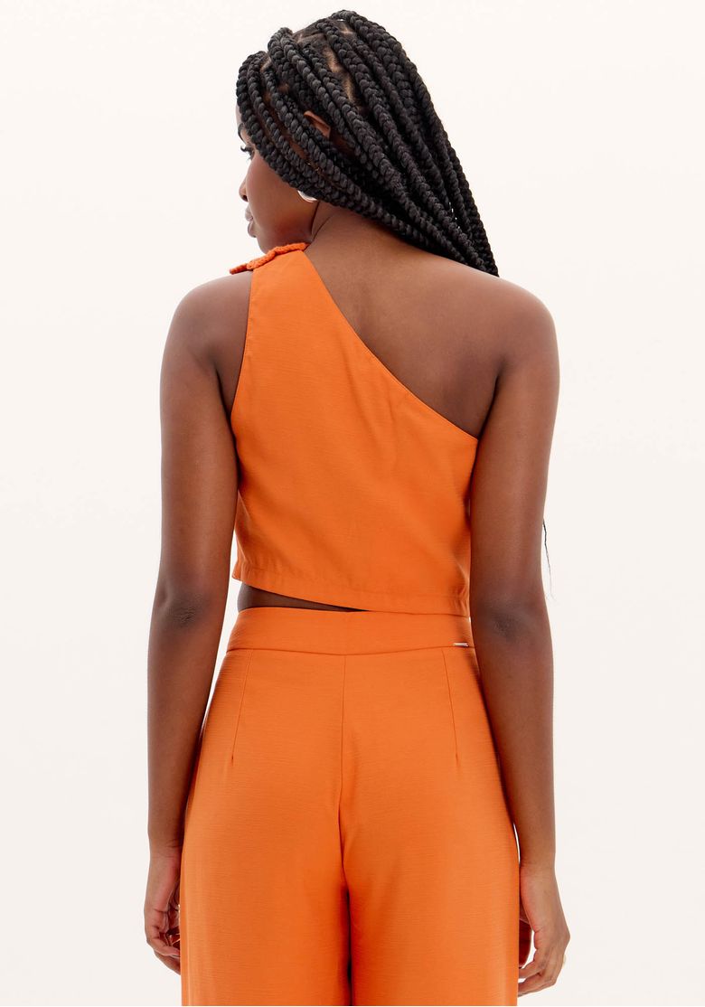 Close-up da alça com flor de crochê da blusa cropped laranja - detalhe artesanal