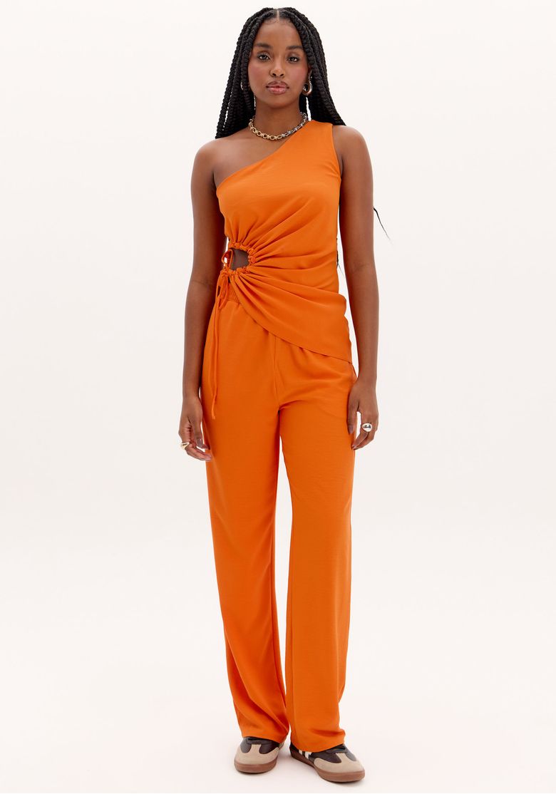 Modelo vestindo calça reta laranja com cós elástico, vista frontal.