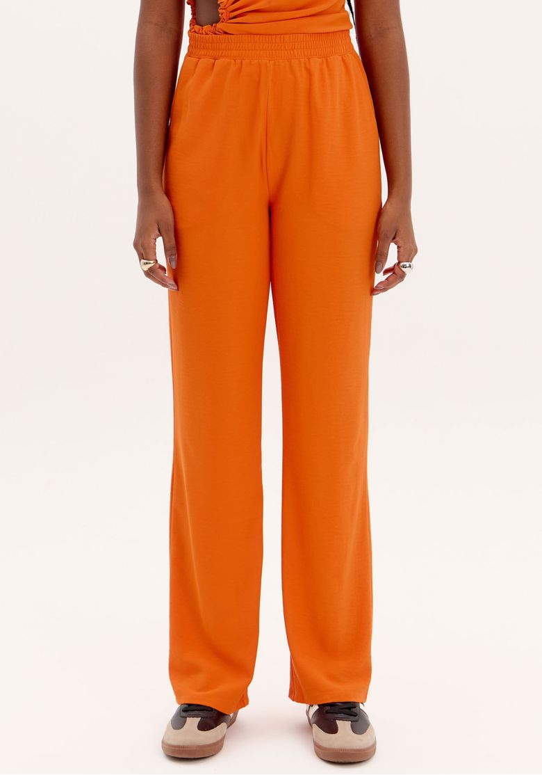 Detalhe do cós elástico da calça reta laranja.