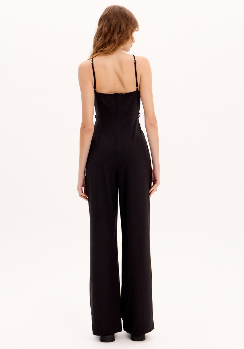Macacão longo preto feminino costas, com alças finas reguláveis, zíper central traseiro e modelagem ampla nas pernas.