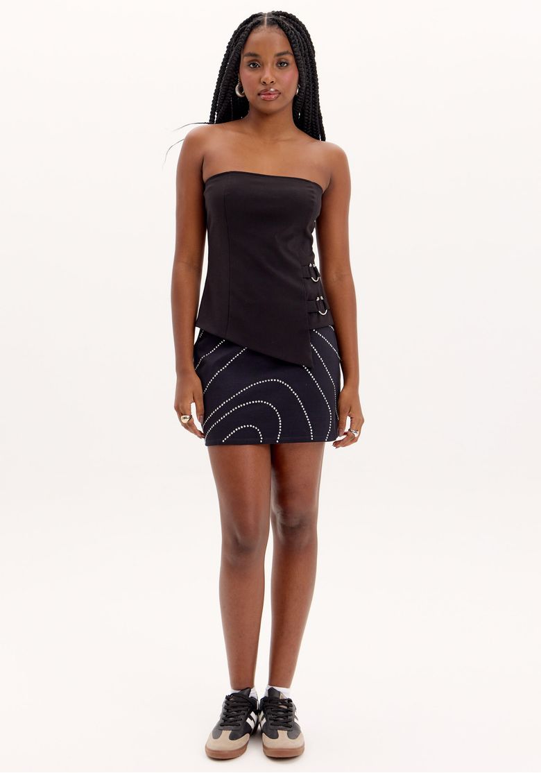 Modelo usando saia curta preta com aplicações de brilhos e cintura alta, em look feminino para festa e ocasiões noturnas