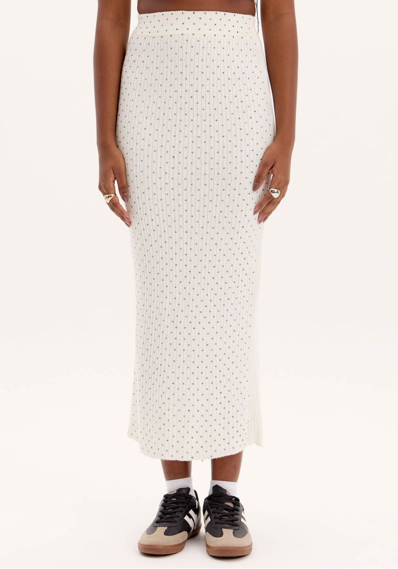Look frontal com top cropped e saia midi tricot branca com brilhos; top de alças finas e saia cintura alta em corte lápis, visual completo para noite.