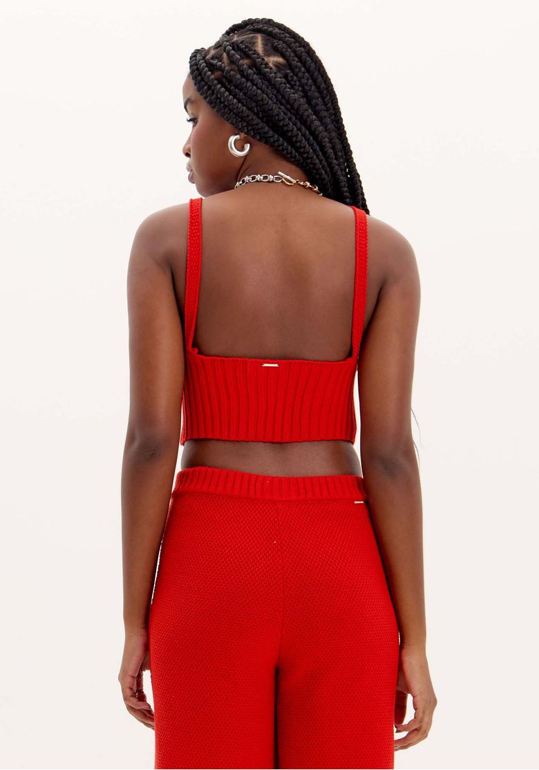 Vista de costas do top cropped tricot vermelho com alças finas e cós canelado, parte do conjunto tricot