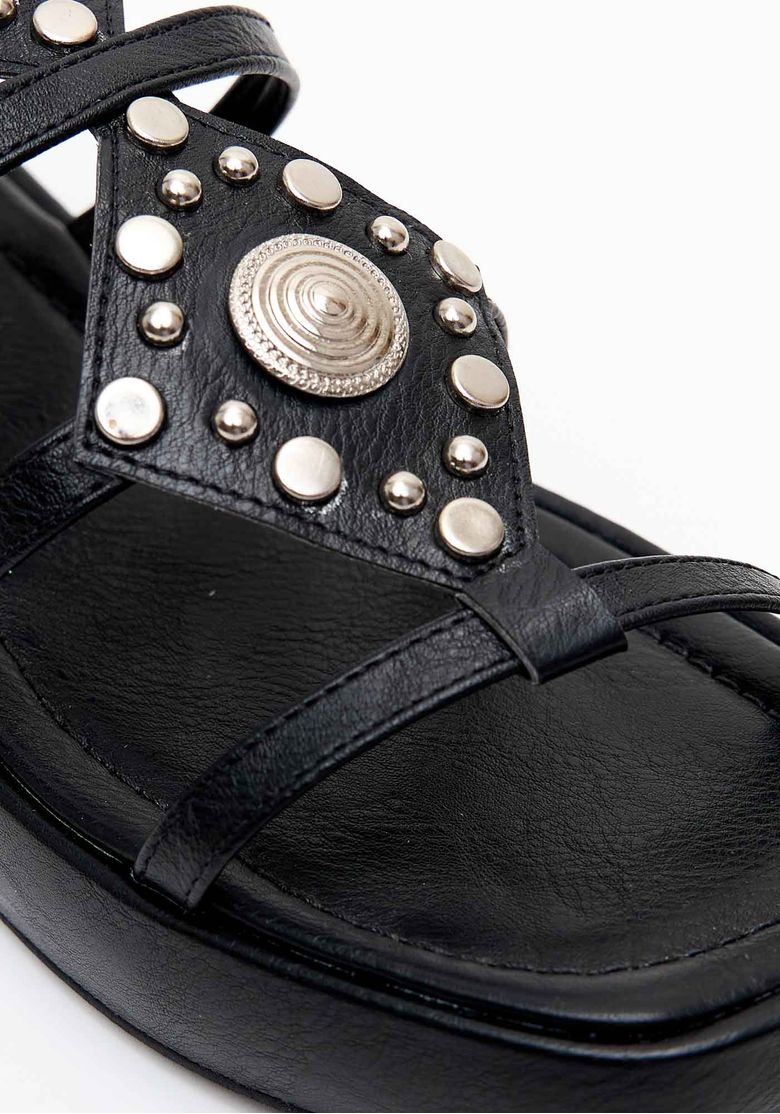Visão 3/4 da sandália flatform com duas fivelas ajustáveis no tornozelo e tiras transversais