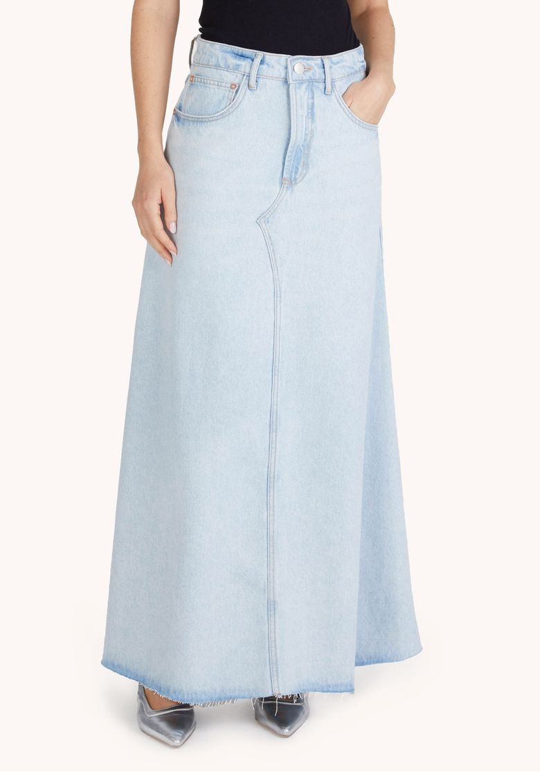 Close frontal da saia jeans azul clara longa com cintura alta, bolsos frontais e barra ampla