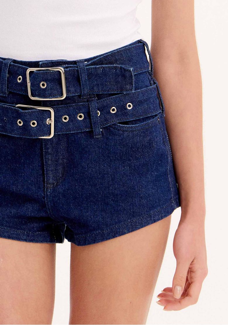 Detalhe do cinto ajustável e cós com passantes do short jeans hot pants azul.