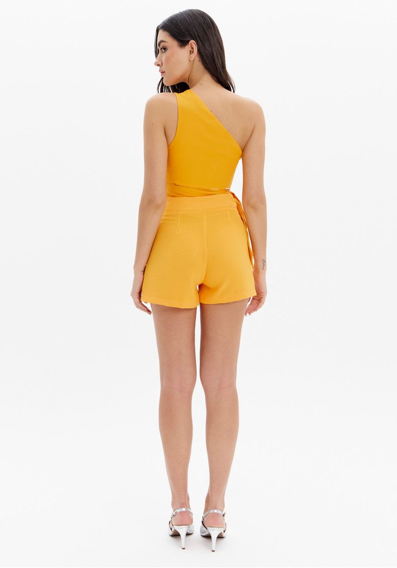 Vista traseira do short laranja com cintura alta e top assimétrico.