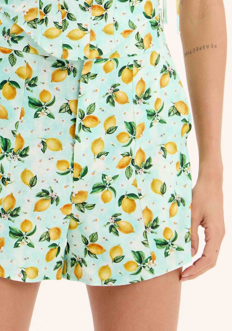 Detalhe do tecido estampado com limões sicilianos do short de alfaiataria.