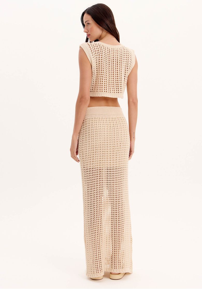 Vista traseira da saia longa de tricot bege com cintura alta e caimento reto, combinada com top cropped de tricot