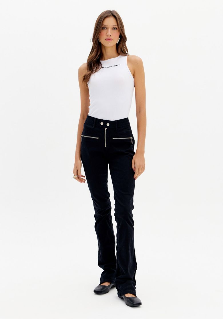 Modelo vestindo calça de sarja preta boot cut com top branco, vista frontal.