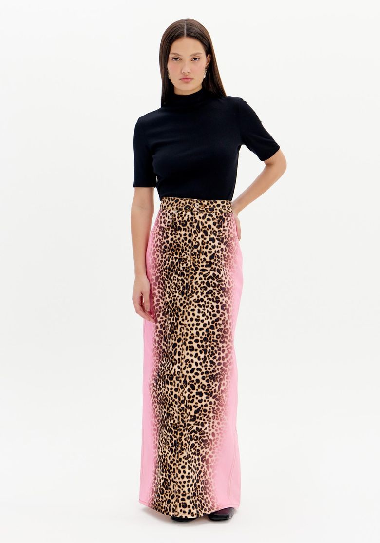 Modelo vestindo saia midi com estampa animal print e detalhe degradê lateral, combinada com blusa preta de gola alta.
