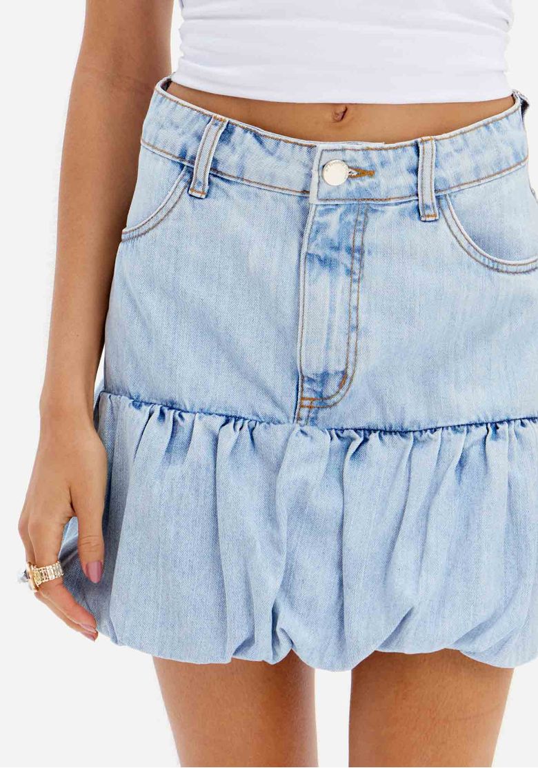 Detalhe da saia jeans balonê mostrando o cós com passantes e o tecido denim.