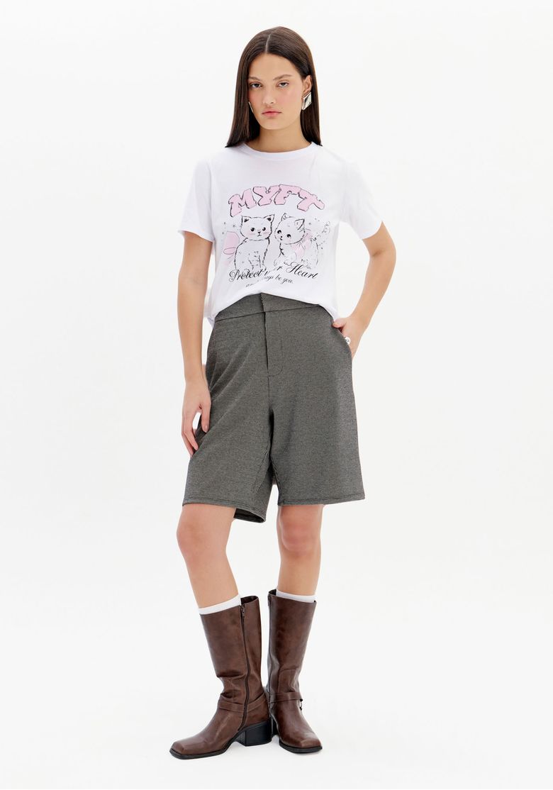 Modelo vestindo bermuda de alfaiataria xadrez com camisa branca e botas marrons.