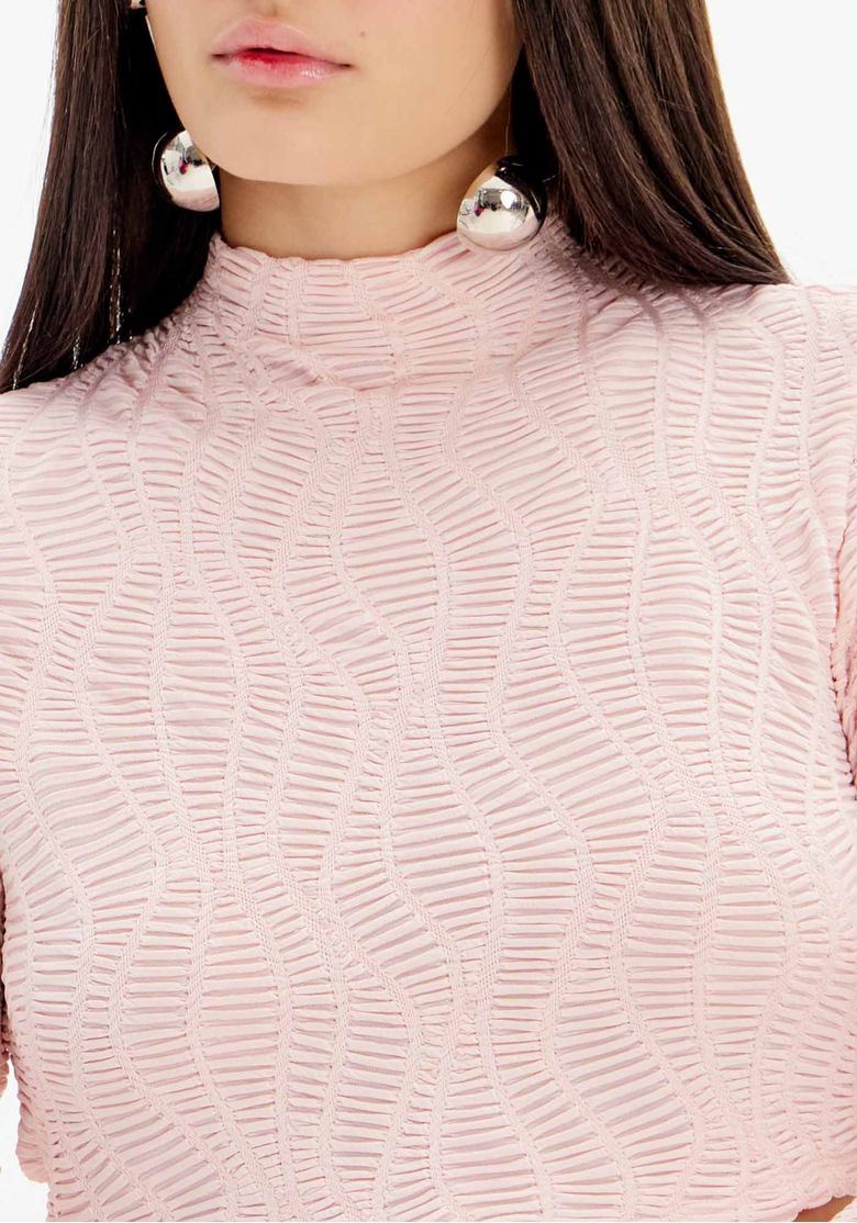 Close da blusa cropped feminina rosa texturizada com gola alta e manga longa, destacando o padrão em relevo