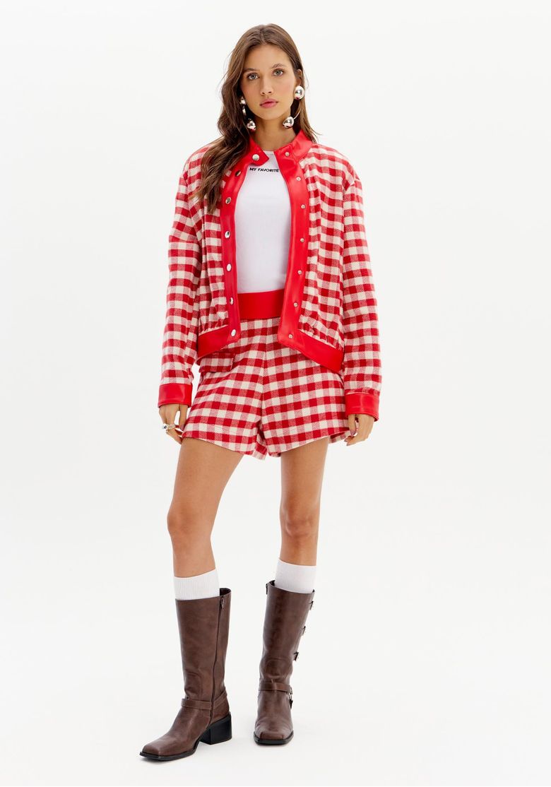 Look completo com jaqueta xadrez curta feminina vermelha, shorts coordenado e bota de cano médio em produção urbana fashion