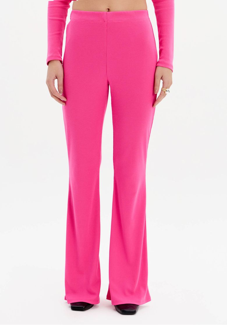 Detalhe da cintura alta e modelagem ajustada da calça flare canelada rosa.