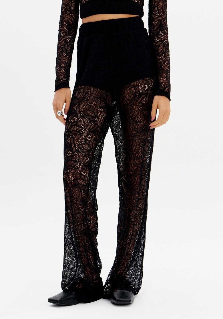 Close frontal da calça de renda preta com modelagem reta, transparência e hot pants embutido