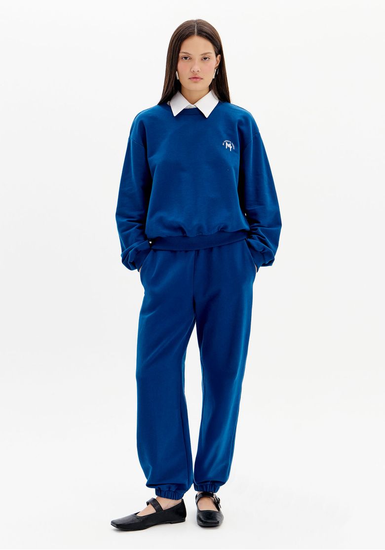 Vista frontal da calça de moletom azul feminina de comprimento longo com barra elástica e caimento confortável