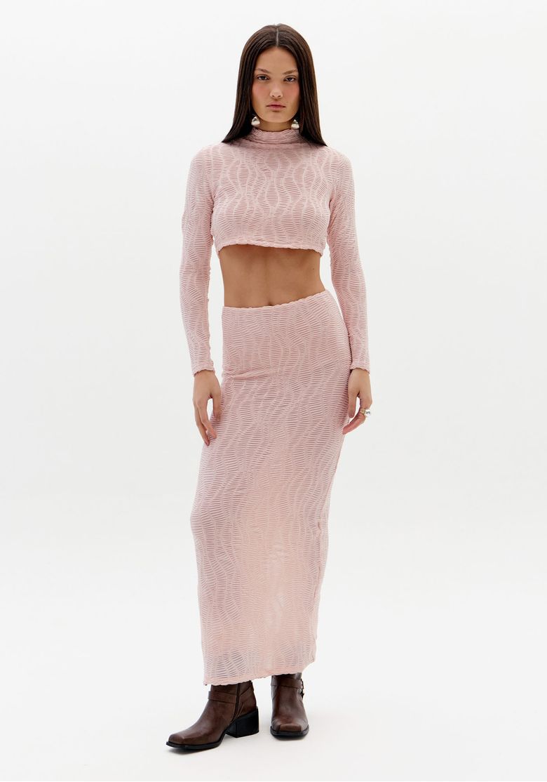 Modelo vestindo saia midi reta texturizada rosa com top combinando, vista frontal.