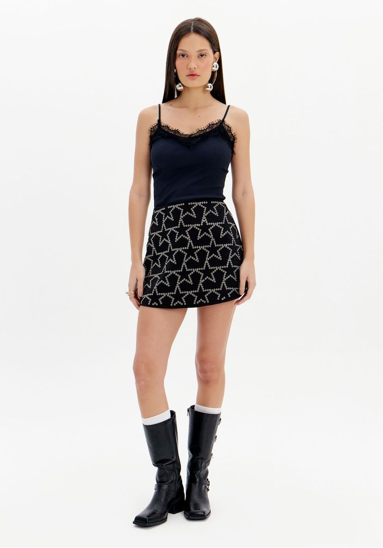 Modelo-usando-short-saia-preto-com-estrelas-brilhantes-e-top-preto-com-alcas-finas.