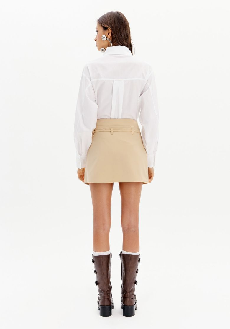 Vista-traseira-do-short-saia-bege-com-camisa-branca.