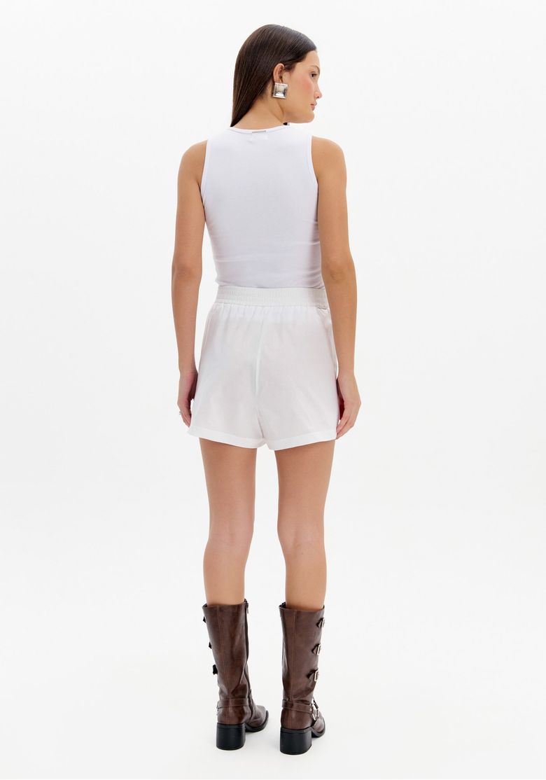 Detalhe do bordado de coração rosa no short boxer branco.