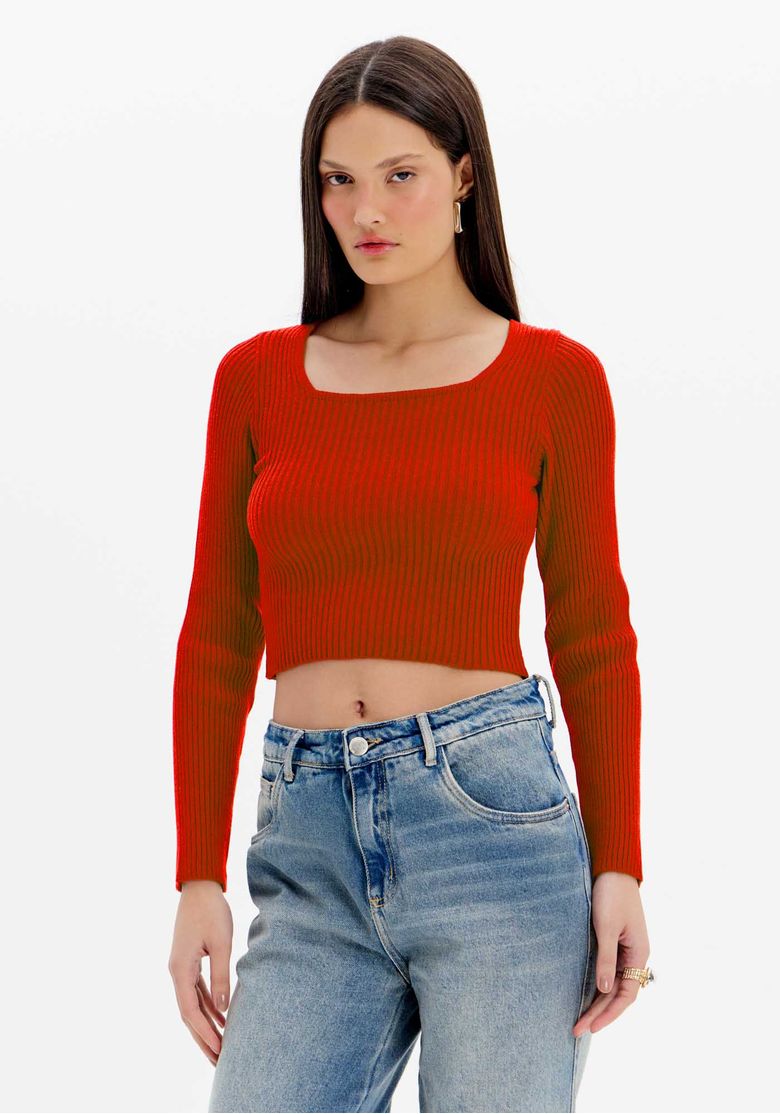 Modelo vestindo blusa cropped de tricot vermelho com mangas longas e decote em U, vista frontal.