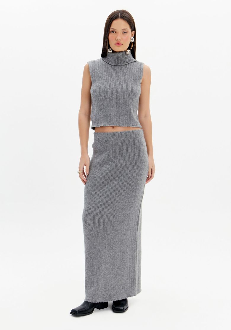 Modelo vestindo saia midi de tricot cinza com fenda traseira, combinada com top de tricot.
