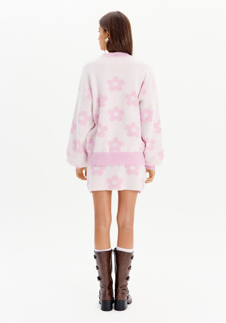 Vista traseira da saia curta de tricô com estampa floral rosa e cardigan combinando.