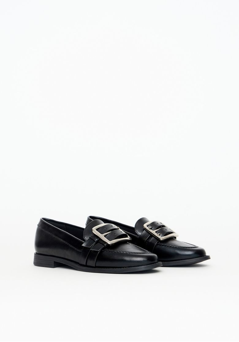 Mocassim preto com detalhe em fivela dupla, vista lateral direita.