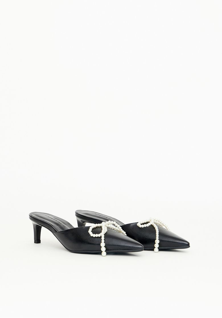Par de scarpins mule preto com detalhes de laço de pérolas.
