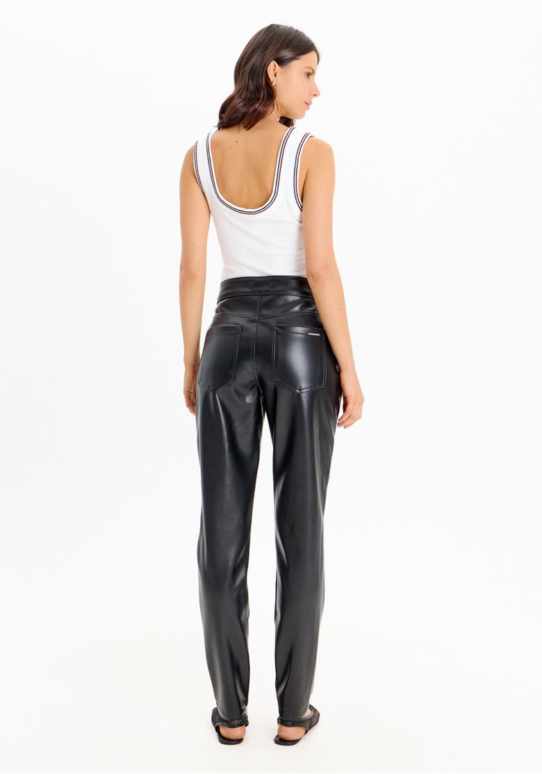 Vista traseira de mulher usando calça skinny preta em material sintético com cintura alta e bolsos traseiros aplicados
