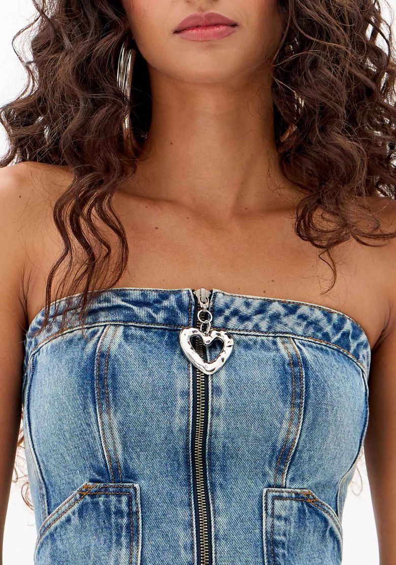 Close da blusa jeans tomara que caia azul com zíper frontal aparente e puxador de coração