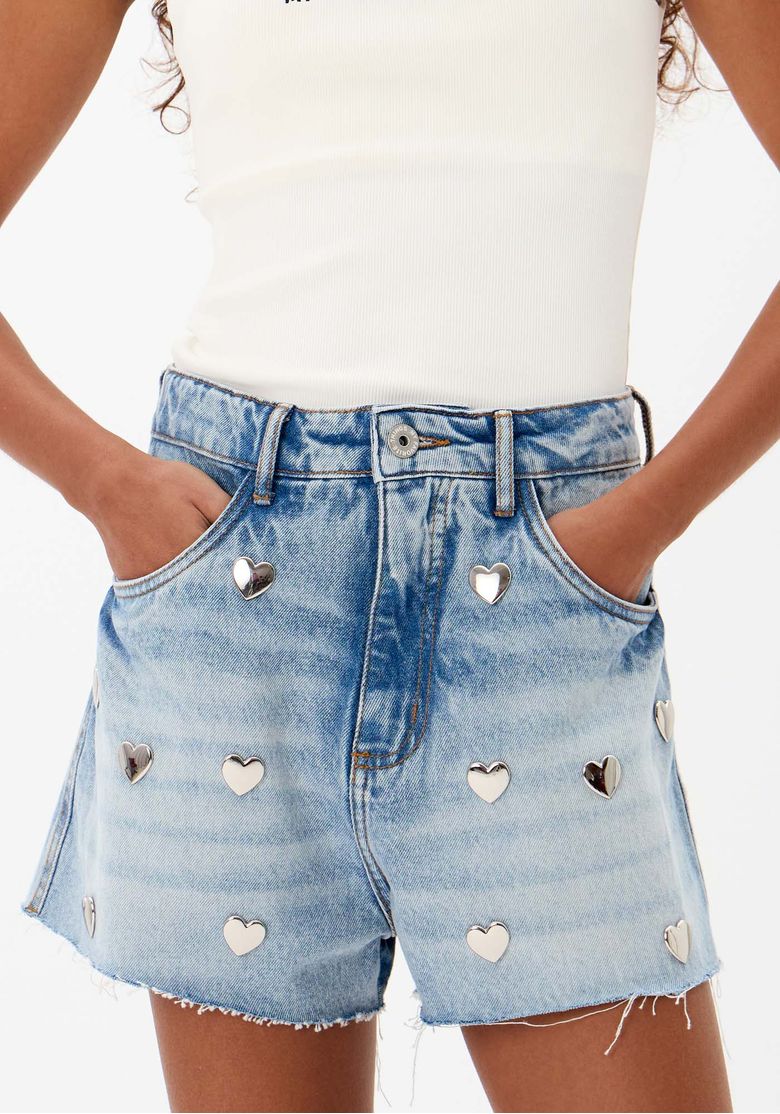 Detalhe da cintura do short jeans grandfather com passantes e fechamento por botão.