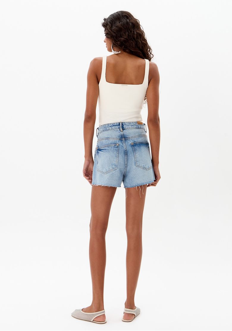 Vista traseira do short jeans grandfather com bolsos e barra desfiada.