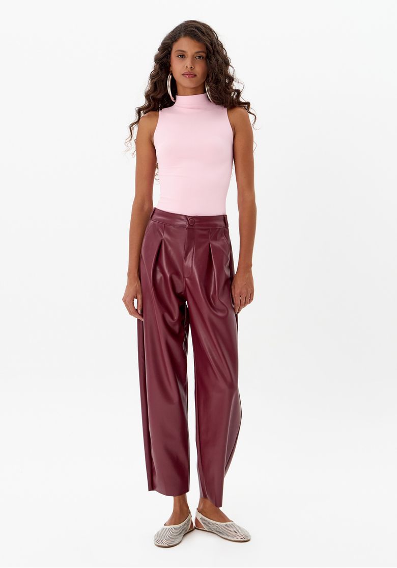 Modelo usando calça baggy vermelha com top rosa, vista frontal.