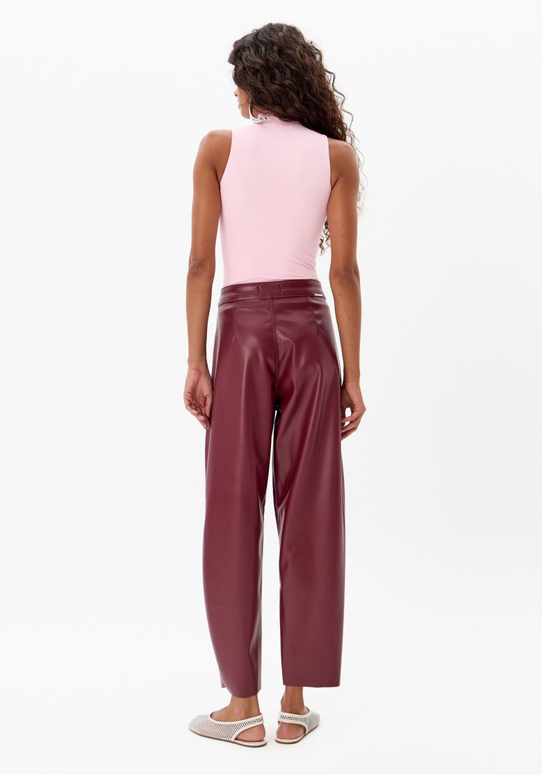 Vista traseira da calça baggy vermelha com top rosa.