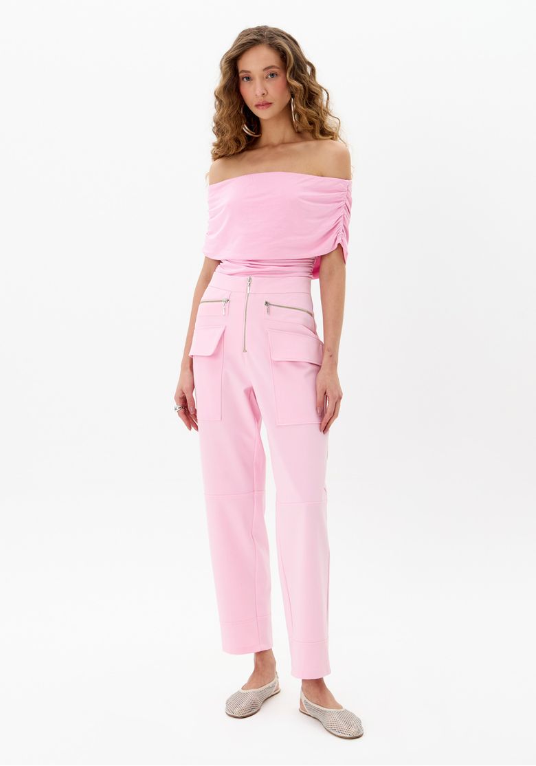 Modelo vestindo calça reta rosa com bolsos cargo e top drapeado, vista frontal.