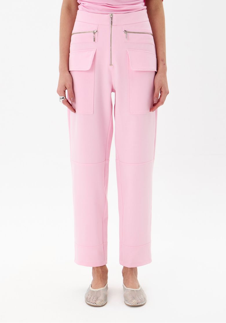 Detalhe dos bolsos cargo e fechamento com zíper da calça rosa.