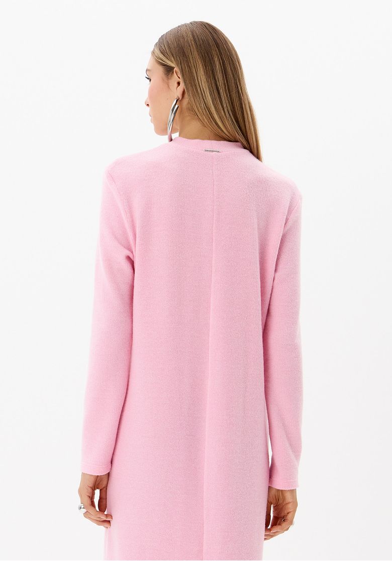 Detalhe posterior do vestido de tricot rosa com manga longa, caimento solto e acabamento liso minimalista