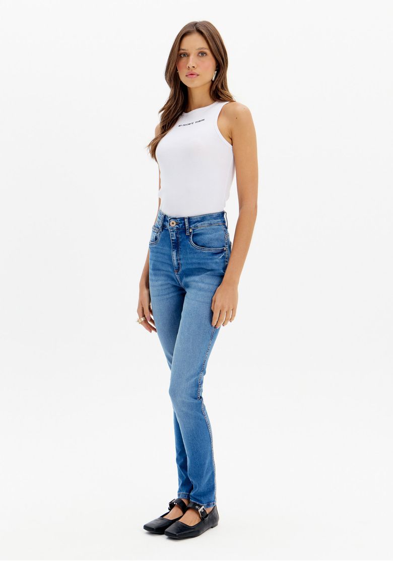 Modelo vestindo calça jeans skinny azul com cintura alta, vista frontal completa.