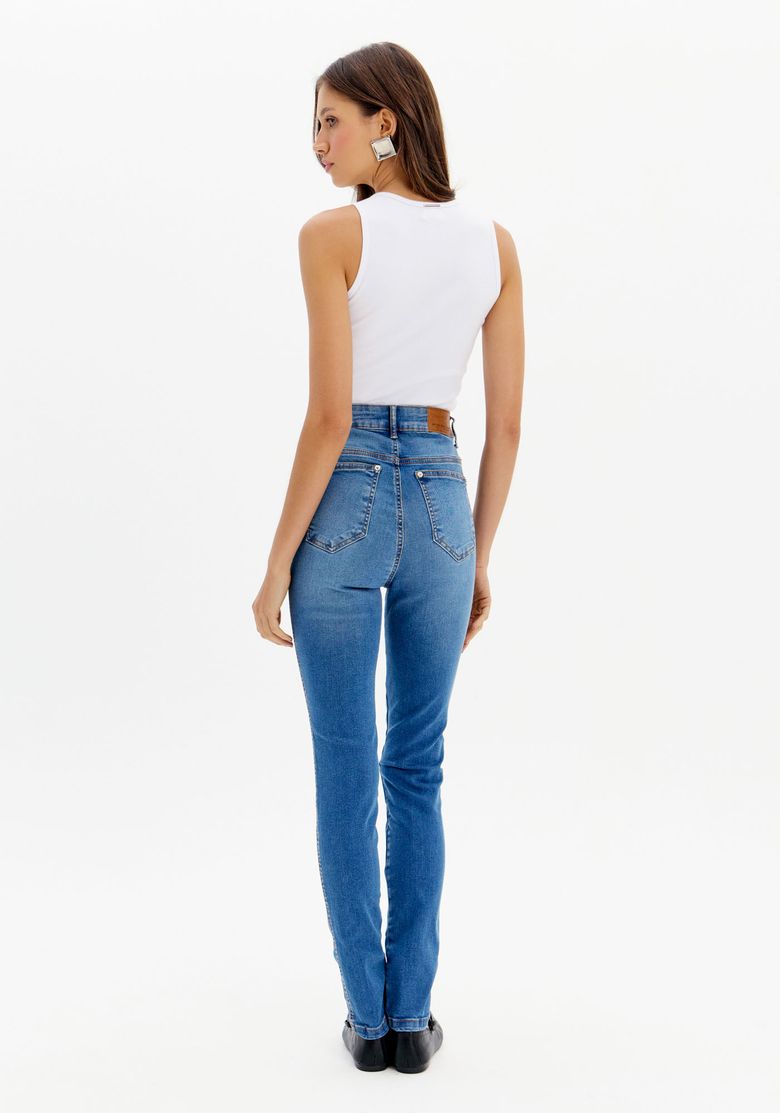 Vista traseira da calça jeans skinny azul, destacando o ajuste e os bolsos traseiros.