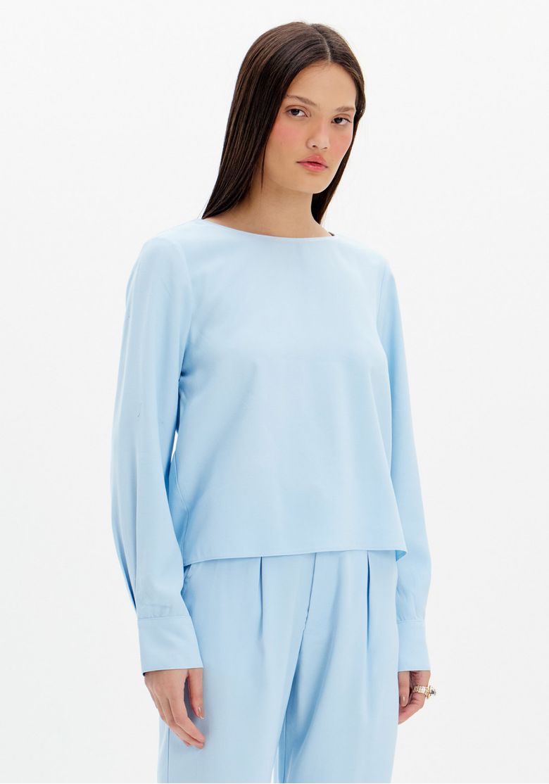 Blusa azul de manga longa vista de frente, com modelagem reta e gola redonda.