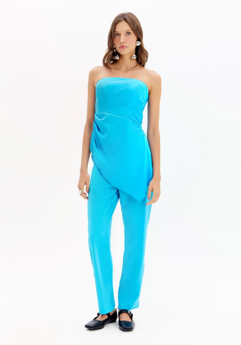 Modelo usando calça reta de alfaiataria azul e top tomara-que-caia drapeado, vista frontal de corpo inteiro mostrando o caimento e comprimento longo.