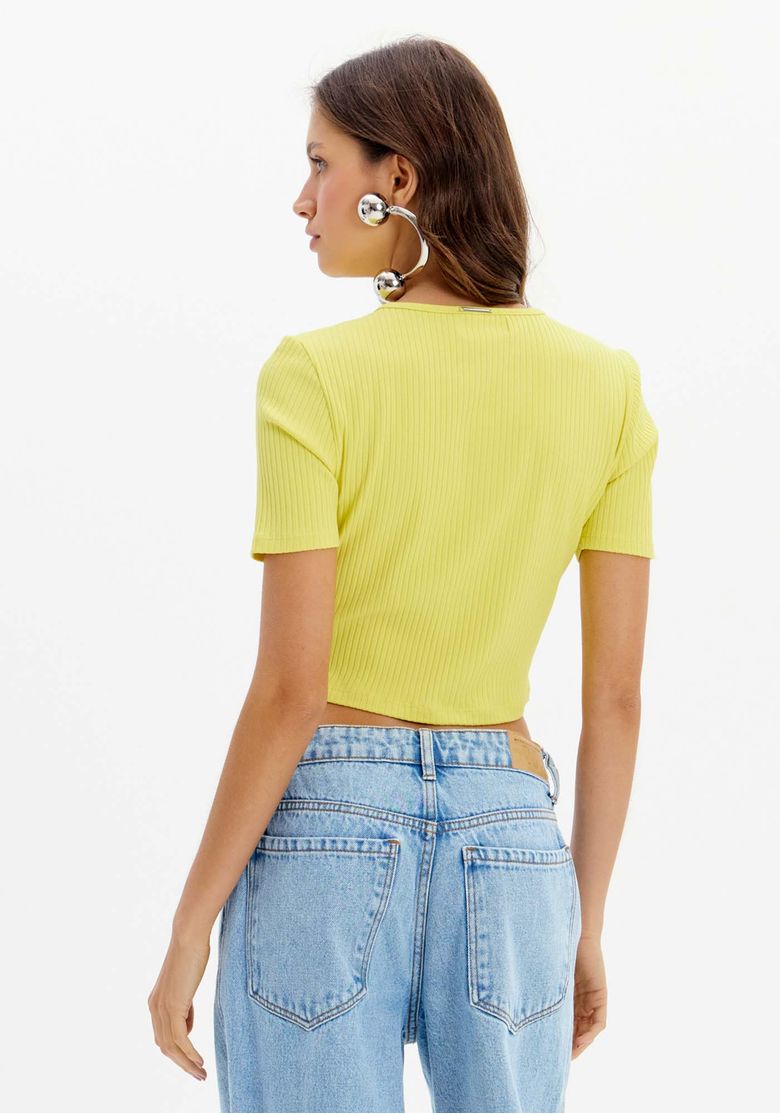 Look completo com blusa cropped canelada, calça jeans de lavagem clara e sapato marrom, styling casual para o dia a dia