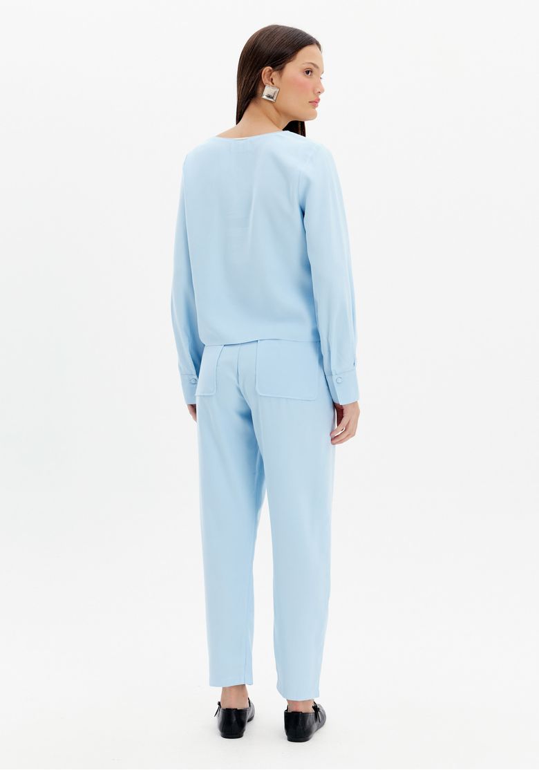 Vista traseira da calça baggy azul destacando os bolsos embutidos e o corte reto.